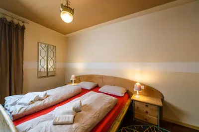 a bedroom with two beds and a desk with two lamps at Ciasa Gianot in Moena