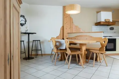 a kitchen with a wooden table and chairs at Ciasa Gianot in Moena