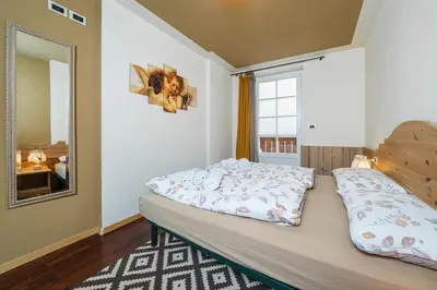 a bedroom with a bed and a large window at Ciasa Gianot in Moena