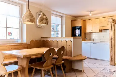 a kitchen with a wooden table and chairs at Ciasa Gianot in Moena