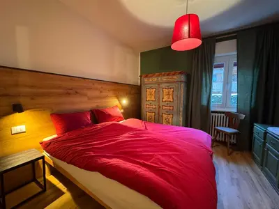 a bedroom with a large red bed with a red blanket at Villa Ginestra - 1 in Moena