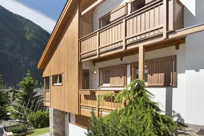 a building with wooden balconies and stairs on it at Appartamenti Decrestina in Campitello di Fassa
