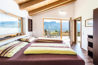 two beds in a room with a balcony at Eggbauer Panorama Apartments in Cermes