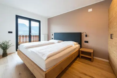 a large bed in a bedroom with a large window at Eggbauer Panorama Apartments in Cermes