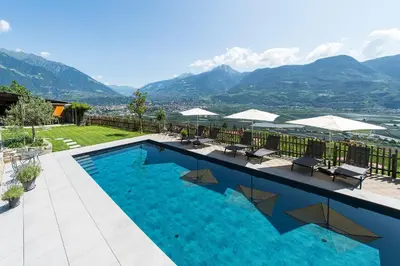 a swimming pool with a view of mountains at Eggbauer Panorama Apartments in Cermes