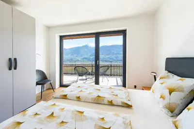 a bedroom with a bed and a large window at Eggbauer Panorama Apartments in Cermes