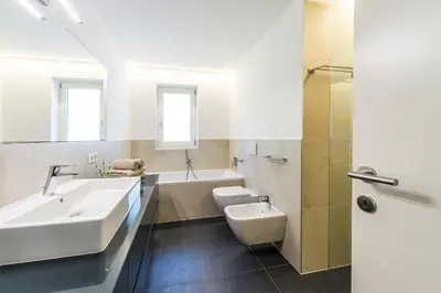 a bathroom with a sink and a toilet and a tub at Eggbauer Panorama Apartments in Cermes