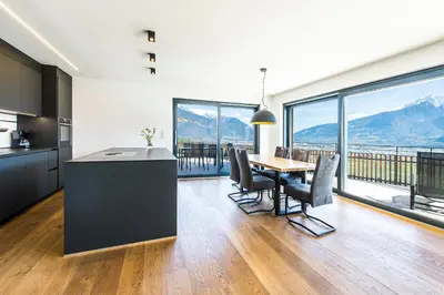 a kitchen and dining room with a view of mountains at Eggbauer Panorama Apartments in Cermes