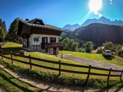 a bedroom with a bed and a wooden ceiling at Chalet della Civetta in Pianaz