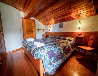 a room with a bed and a large window at Chalet della Civetta in Pianaz