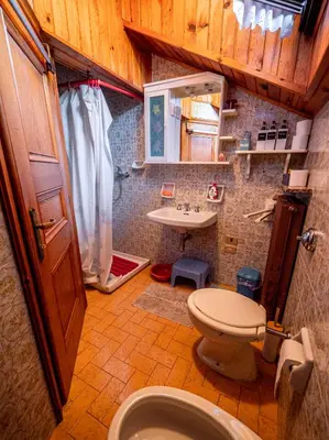 a bedroom with a bed in a room with wooden floors at Chalet della Civetta in Pianaz