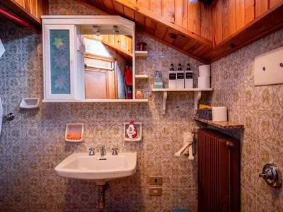 a bed in a room with a wooden ceiling at Chalet della Civetta in Pianaz