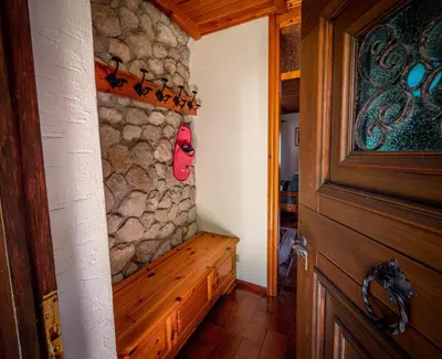 a room with a wooden door and a stone wall at Chalet della Civetta in Pianaz