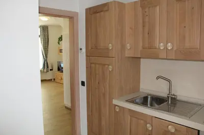 a kitchen with wooden cabinets and a sink at Appartamenti Dany in Arabba