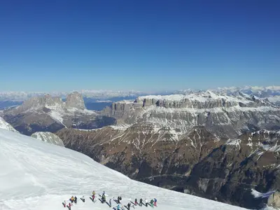 a group of people walking up a snow covered mountain at Appartamenti Dany in Arabba