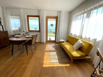 a living room with a yellow couch and a table at Weitblick Apartment mit Garten in Castelvecchio