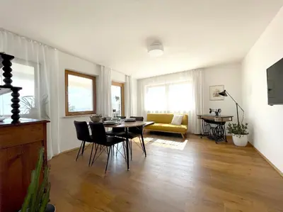 a living room with a table and chairs and a couch at Weitblick Apartment mit Garten in Castelvecchio