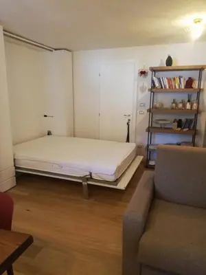 a bedroom with a bed and a couch in it at Monolocale Fiera di Primiero in Fiera di Primiero