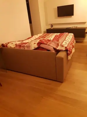 a bed with a quilt on it in a room at Monolocale Fiera di Primiero in Fiera di Primiero