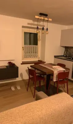 a living room with a dining room table and chairs at Monolocale Fiera di Primiero in Fiera di Primiero