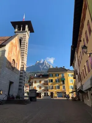 a city street with buildings and a mountain in the background at Monolocale Fiera di Primiero in Fiera di Primiero
