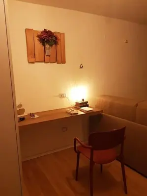 a room with a desk and a chair and a couch at Monolocale Fiera di Primiero in Fiera di Primiero