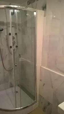 a shower with a glass door in a bathroom at Baita cavalese giardino esclusivo in Cavalese