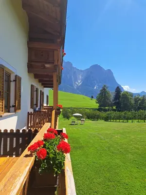 a picnic table and chairs with mountains in the background at Kachlerhof in Castelrotto