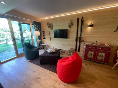 a living room with a couch and a tv at Stella Alpina San Martino di Castrozza vista Pale in San Martino di Castrozza