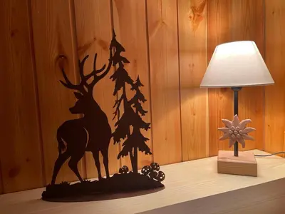 a table with a lamp and a christmas tree and deer stencil at Stella Alpina San Martino di Castrozza vista Pale in San Martino di Castrozza