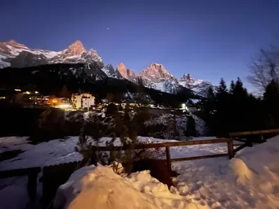 a view of a snowy mountain range at night at Stella Alpina San Martino di Castrozza vista Pale in San Martino di Castrozza
