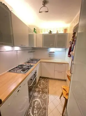 a kitchen with white cabinets and a stove top oven at Stella Alpina San Martino di Castrozza vista Pale in San Martino di Castrozza