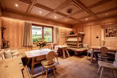a room with a table and chairs and a bunk bed at Hotel Patriarch in Tirolo