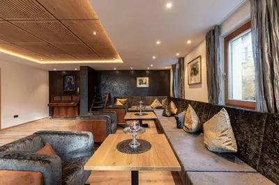 a restaurant with couches and tables in a room at Hotel Patriarch in Tirolo