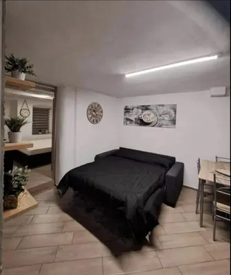 a bedroom with a black bed in a room with a table at Casa Jasmina in Mezzano