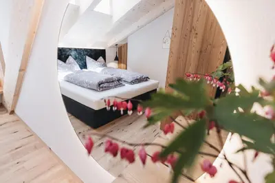 a mirror in a bedroom with a bed in it at Flaschtal-Hof in Nova Ponente