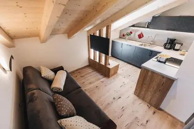 a living room with a couch and a kitchen at Flaschtal-Hof in Nova Ponente
