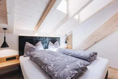 a bedroom with a bed with a gray comforter at Flaschtal-Hof in Nova Ponente