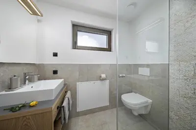 a bathroom with a sink and a toilet and a window at Schattmair Hof in Tirolo