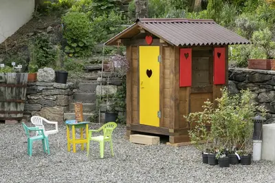 a wooden out house with colorful chairs and tables at Schattmair Hof in Tirolo