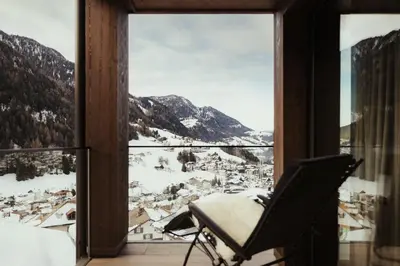 a chair in a room with a view of a snowy mountain at Luxury Chalet P in Ortisei