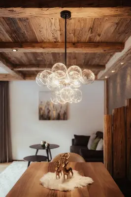 a chandelier and two figurines on a table in a room at Luxury Chalet P in Ortisei