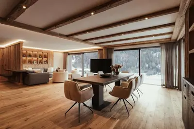 a living room with a dining room table and chairs at Luxury Chalet P in Ortisei