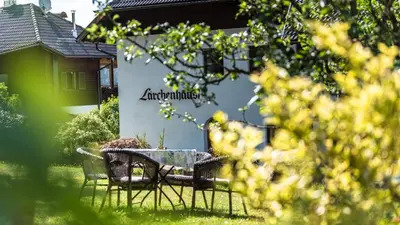 a table and chairs in the yard of a house at Residence Lärchenhäusl in Soprabolzano