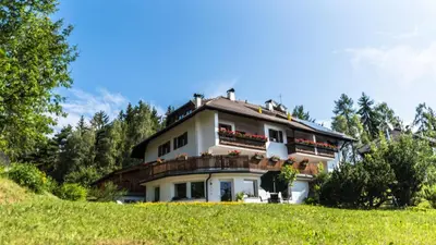 a house with balconies on the side of a hill at Residence Lärchenhäusl in Soprabolzano