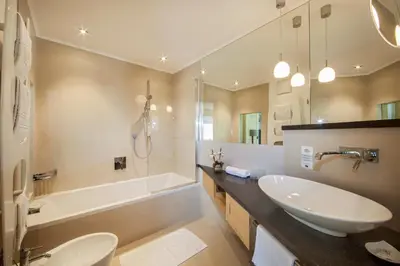 a bathroom with a sink and a tub and a toilet at Garni La Majon in Selva di Val Gardena