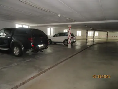 a parking garage with two cars parked in it at Garni La Majon in Selva di Val Gardena