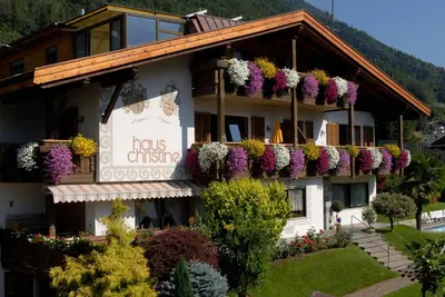 a building with flowers on the side of it at Ferienwohnungen Haus Christine in Rifiano