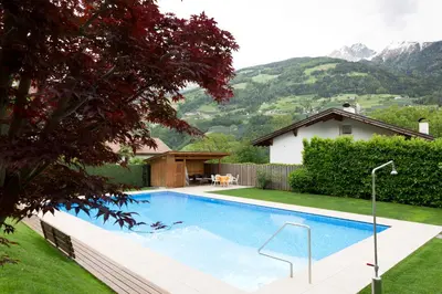 a swimming pool in the backyard of a house at Ferienwohnungen Haus Christine in Rifiano
