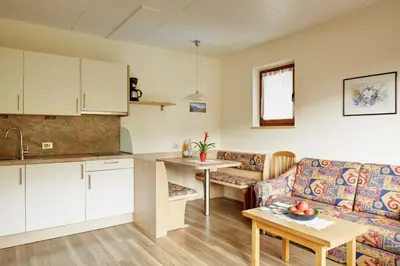 a kitchen and a living room with a couch and a table at Ferienwohnungen Haus Christine in Rifiano